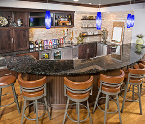 Nw bar in a basement remodeled by S.J. Janis. It features a large, six-chair curved bar area with plenty of storage.