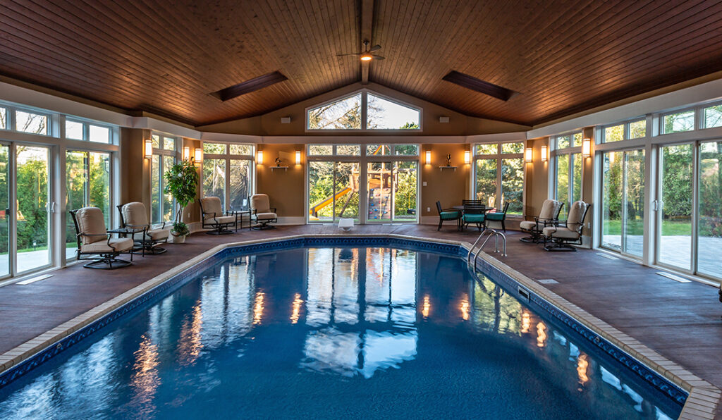 Interior of a large pool room addition in a Brookfield home; built by S.J. Janis. Wood-paneled, vaulted ceiling, sliding glass doors all around.