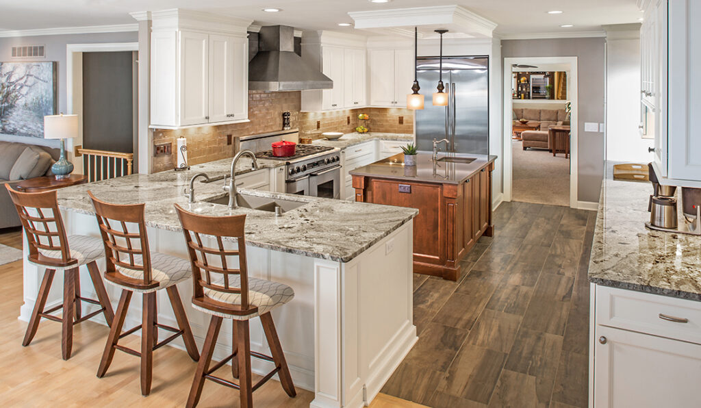 Renovated kitchen featuring a new island, L-shaped counter, custom cabinetry, new fixtures, and new flooring.