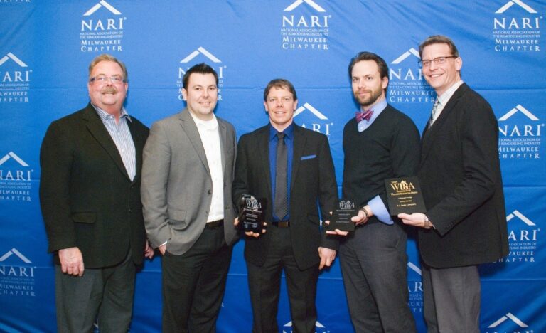 Five people pose with awards in front of a NARI Milwaukee Chapter banner, dressed formally and smiling for the camera.