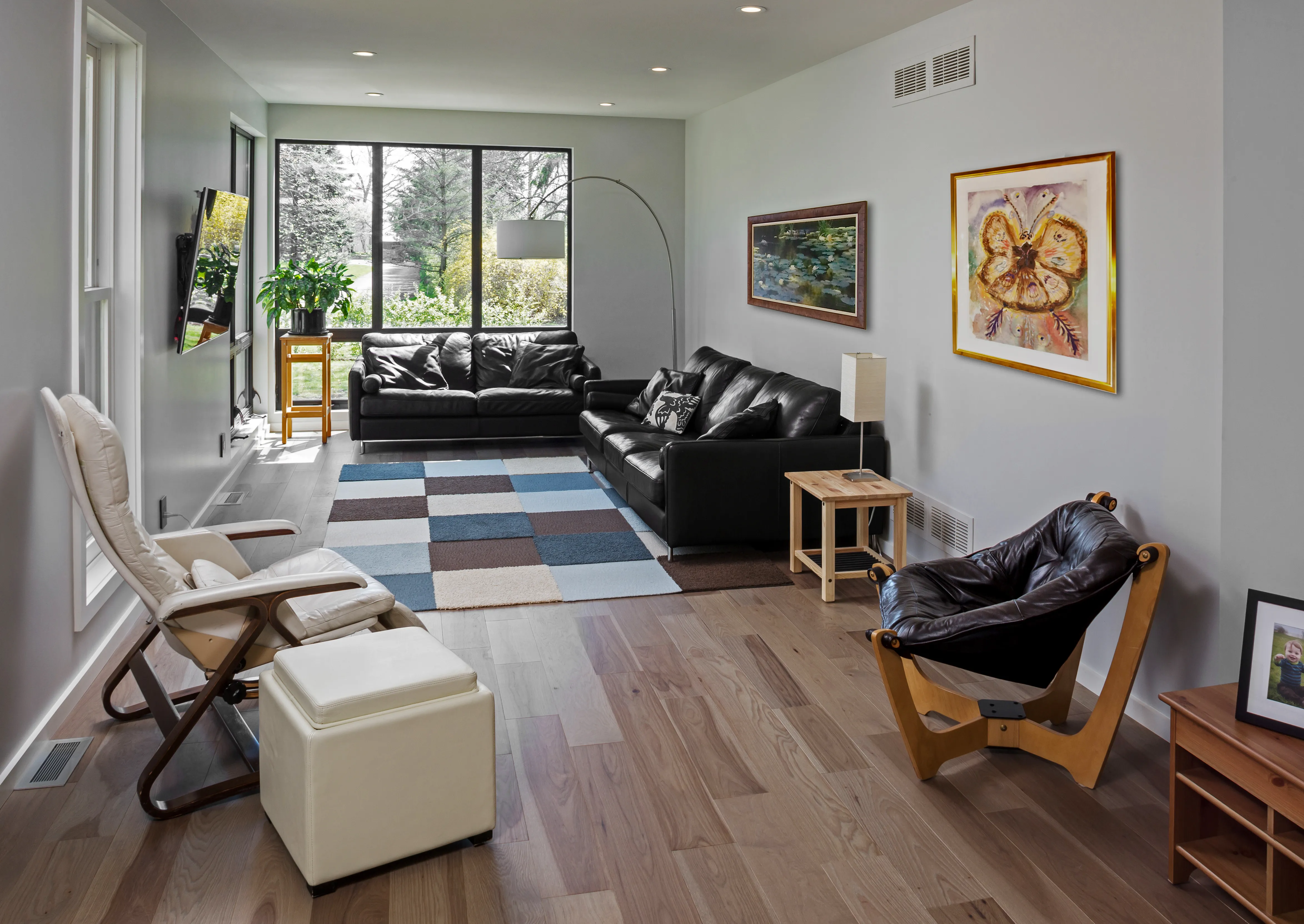 Remodeled living room addition in Fox Point, WI with hardwood floors and modern windows